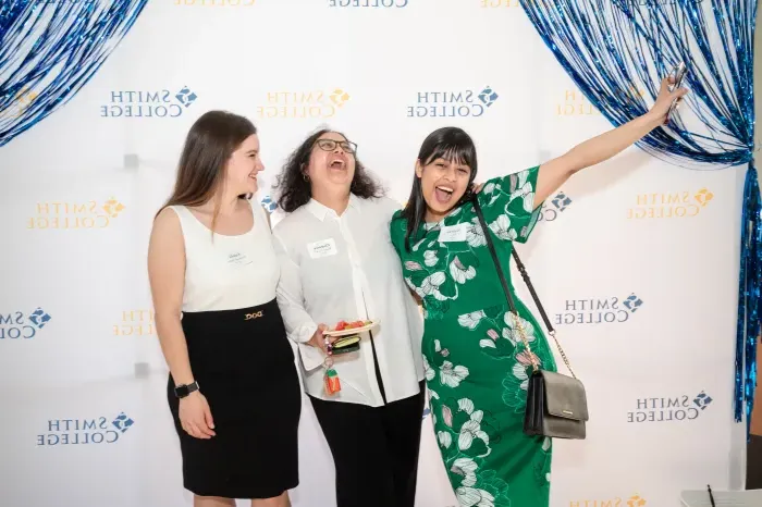 Three students laughing together at the senior soiree.